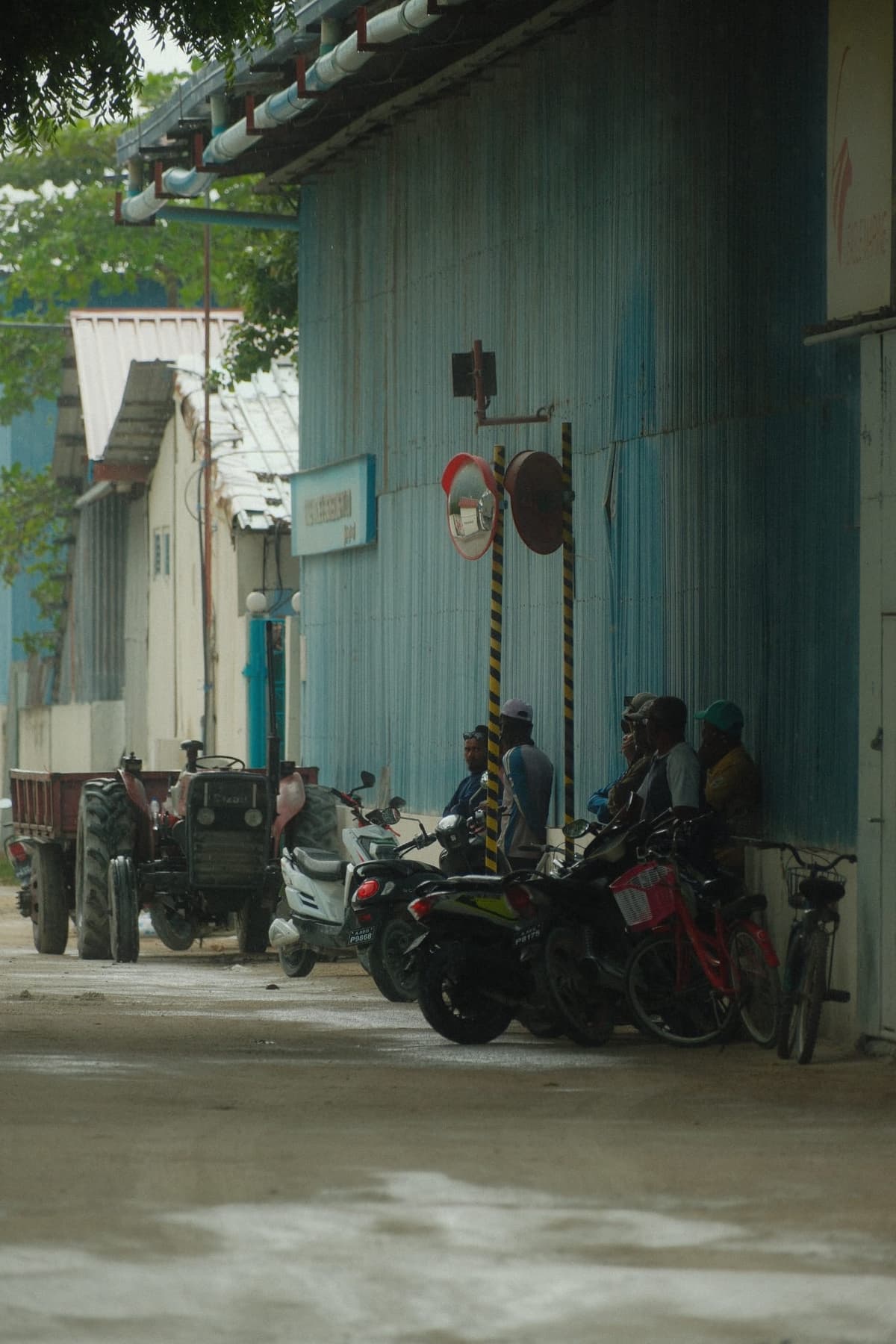 Midday shade against corrugated blue, bikes parked and idle